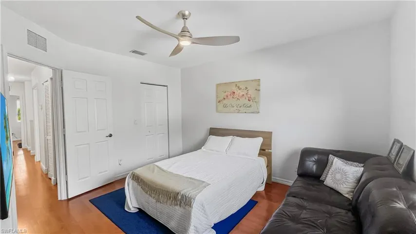 Bedroom featuring dark wood-type flooring, ceiling fan, and a closet