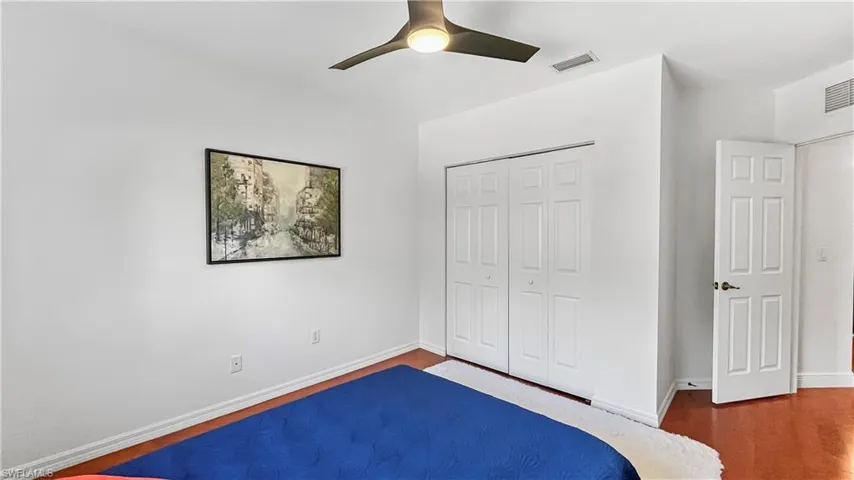 Unfurnished bedroom featuring ceiling fan, a closet, and dark wood-type flooring