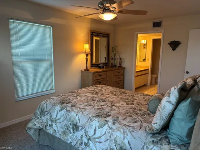 Carpeted Master Bedroom with ceiling fan and water views has adjoining full bath with walk-in shower