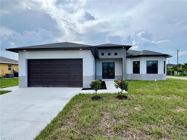 Prairie-style home with a garage, central AC, and a front lawn