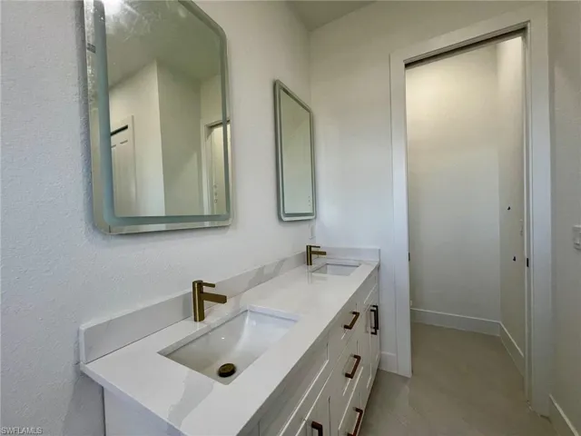 Bathroom featuring tile patterned flooring and double sink vanity