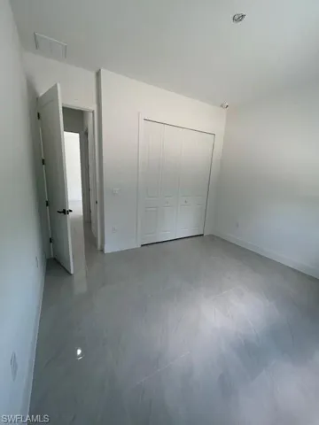 Unfurnished bedroom with tile floors and a closet
