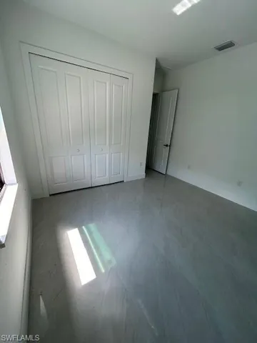 Unfurnished bedroom featuring tile floors and a closet