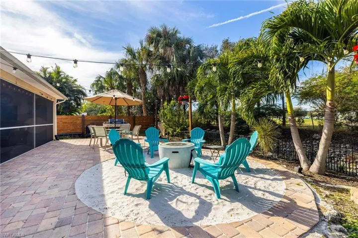 View of patio featuring a sunroom and an outdoor fire pit