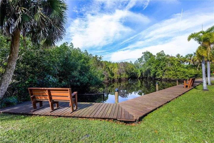 Dock area with a yard and a water view