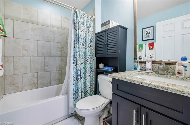 Full bathroom featuring vanity, shower / bath combo, and toilet