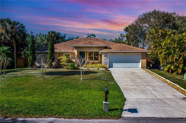 Ranch-style home with a lawn and a garage
