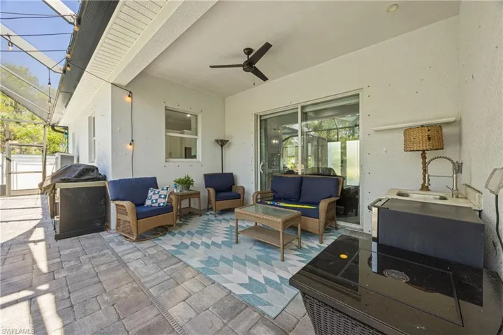 View of patio / terrace with a sunroom, an outdoor living space, a lanai, grilling area, and a ceiling fan