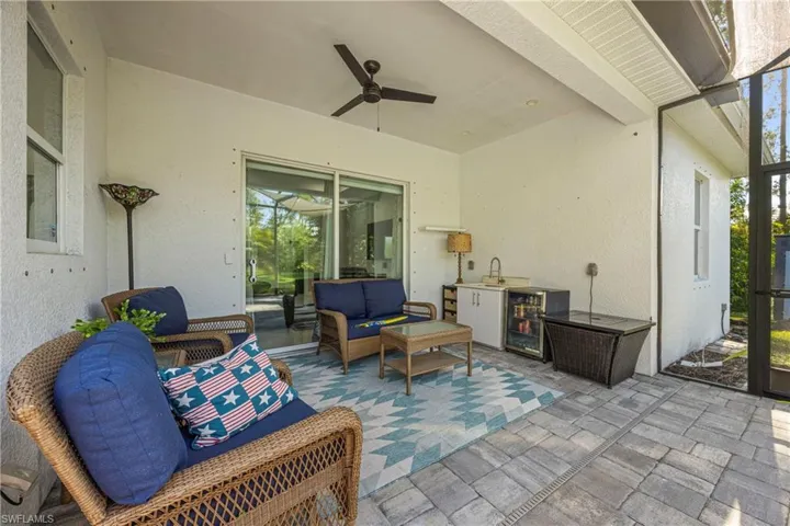 View of patio with outdoor lounge area, ceiling fan, and beverage cooler