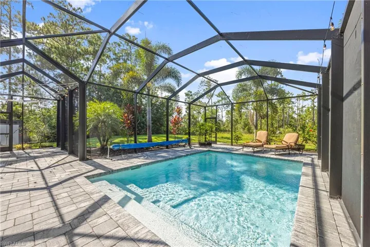Swimming pool with a sunroom, a lanai, and a patio
