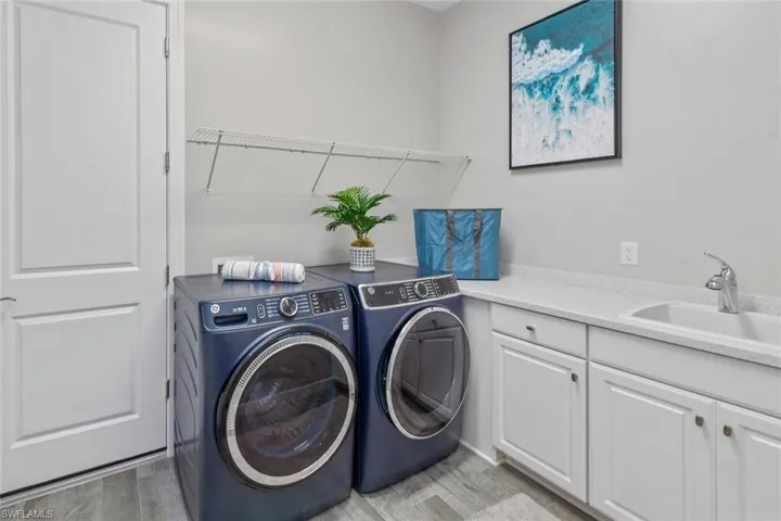Bright and versatile den or home office featuring wood-look tile flooring, recessed lighting, crown molding, and a large window that fills the space with natural light. A wall-mounted TV and ceiling fan add comfort and functionality to this quiet retreat.