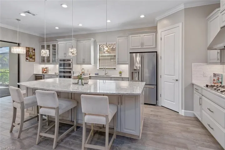 Enjoy stunning lake views from this upgraded, extended covered lanai, featuring modern paver flooring, recessed lighting, and two ceiling fans for year-round comfort. Perfect for outdoor entertaining, with plenty of space to relax by the custom pool and spa.