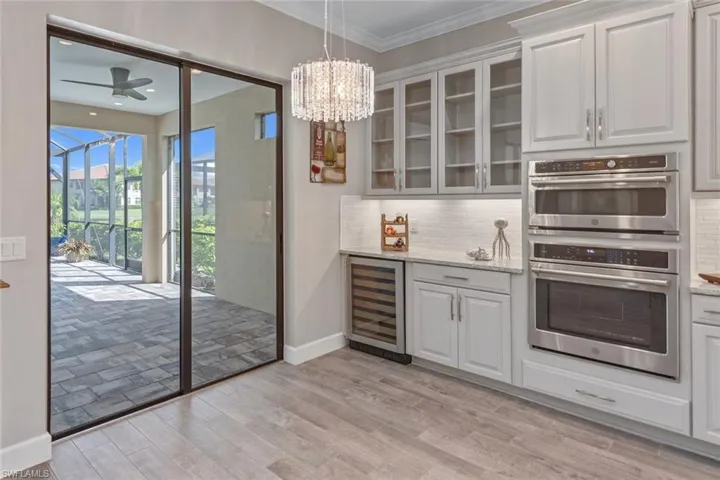 The designer kitchen with large quartz islandand GE Café appliances overlooks the GreatRoom with sliding doors leading to an oversized covered lanai