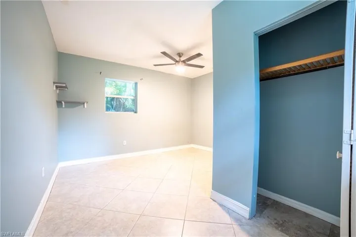 Unfurnished bedroom featuring ceiling fan and light tile patterned flooring
