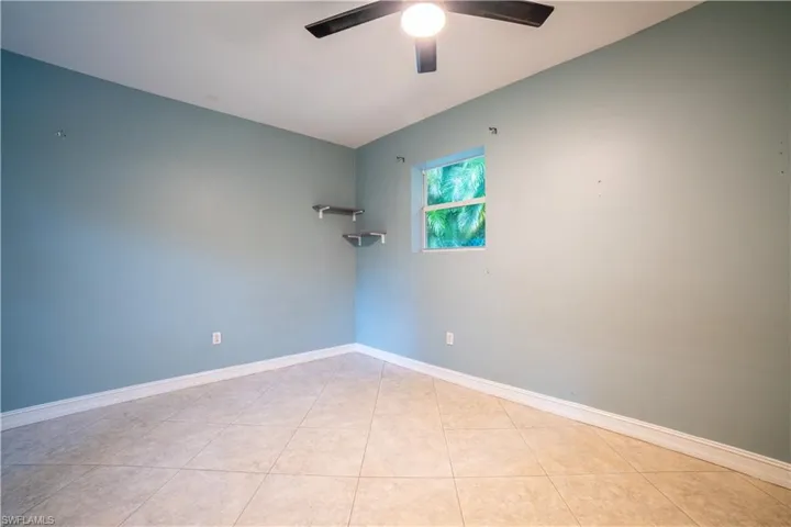 Tiled empty room with ceiling fan
