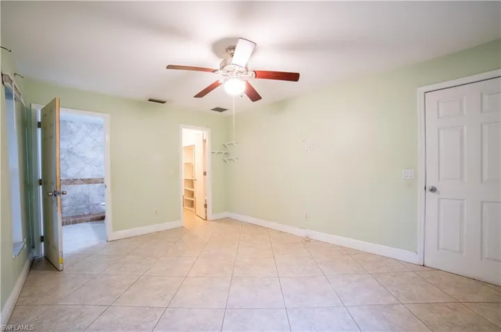 Tiled empty room featuring ceiling fan