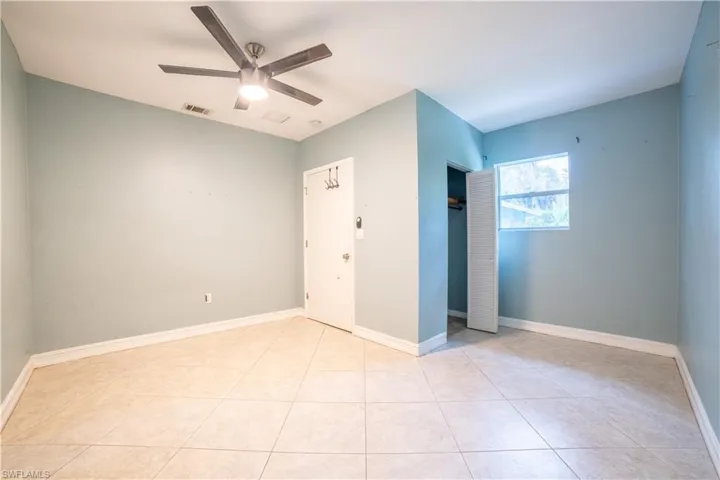Unfurnished bedroom featuring light tile patterned flooring and ceiling fan