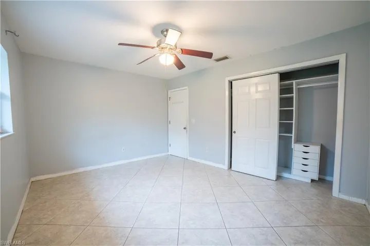 Unfurnished bedroom featuring ceiling fan, a closet, and light tile patterned floors