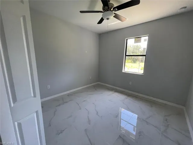 Tiled spare room with ceiling fan