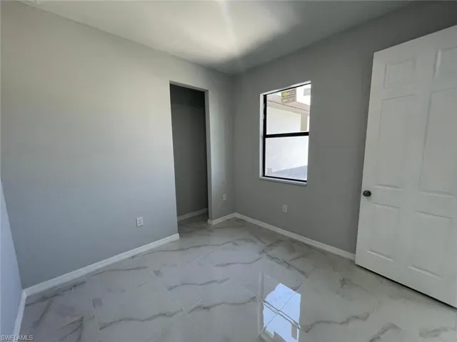 Unfurnished bedroom with light tile flooring