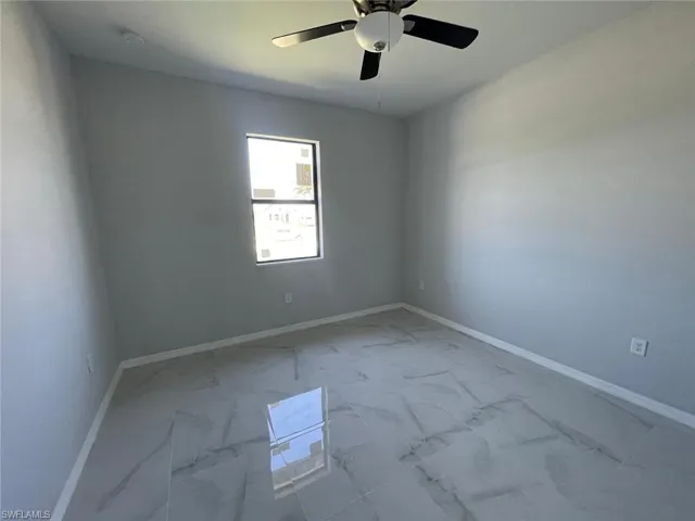 Tiled empty room featuring ceiling fan