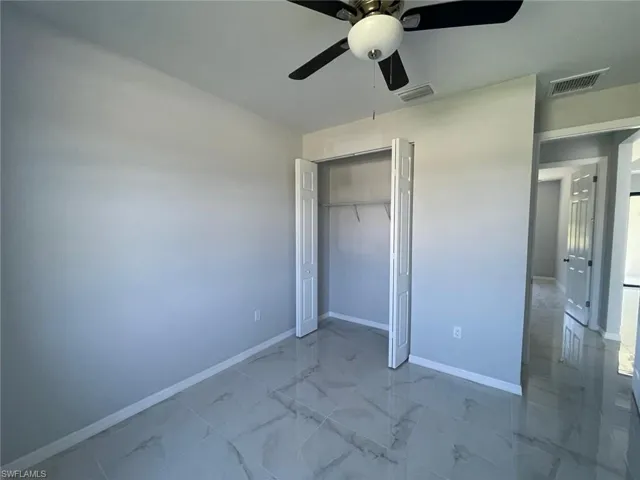 Unfurnished bedroom with tile floors, ceiling fan, and a closet