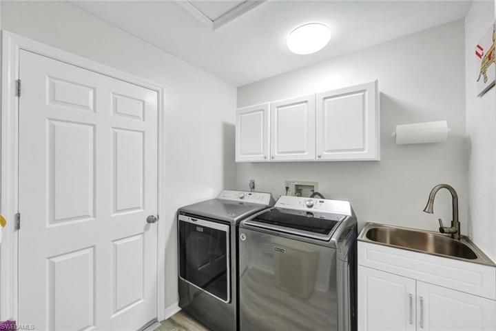 Inside Laundry with utility sink and cupboards