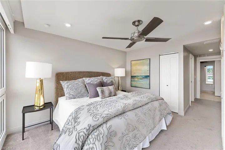 Bedroom with light carpet, a closet, and recessed lighting