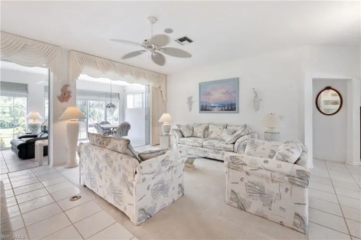 Living room featuring ceiling fan, a wealth of natural light, and light tile patterned floors