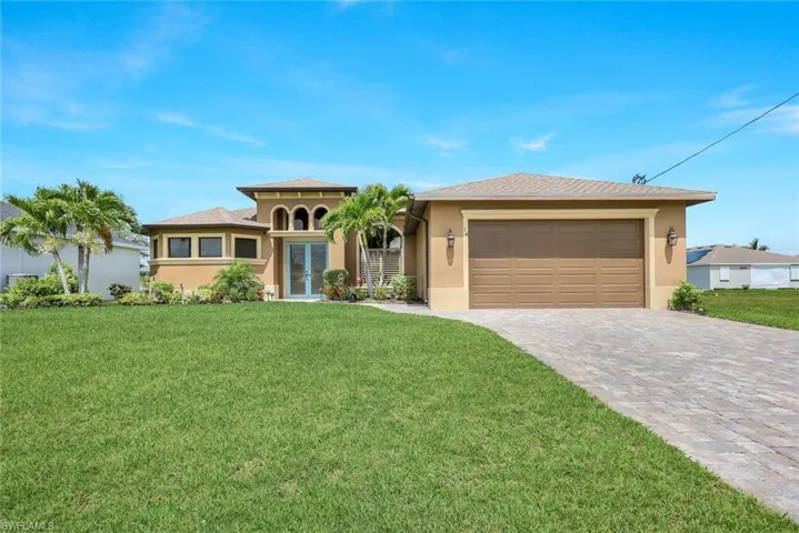 View of front of house with a garage and a front yard