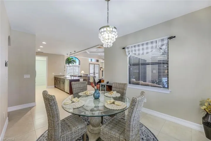 Dining area with a notable chandelier, sink, and light tile floors