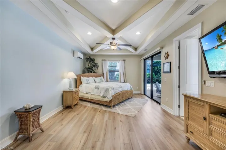 PriBedroom featuring a wall unit AC, ceiling fan, light wood-type flooring, and access to outside