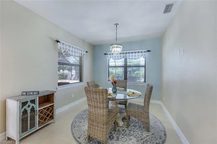 Dining room with a wealth of natural light, an inviting chandelier, and light tile flooring