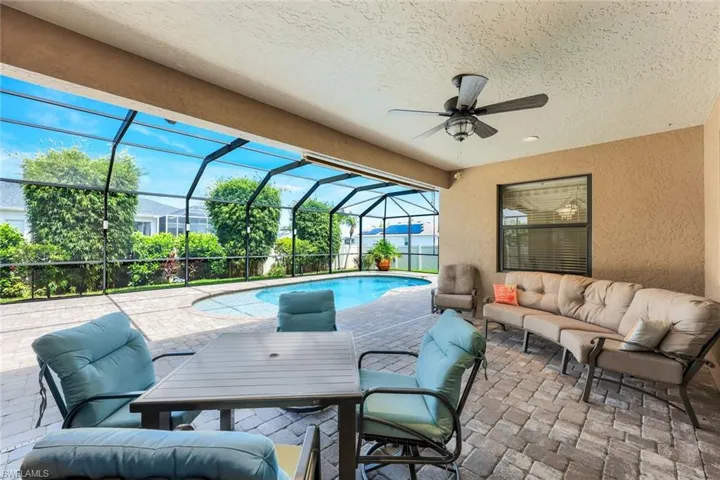 View of swimming pool featuring outdoor lounge area, a lanai, ceiling fan, and a patio area