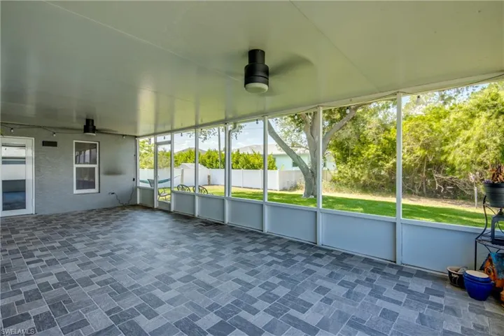 Unfurnished sunroom featuring ceiling fan