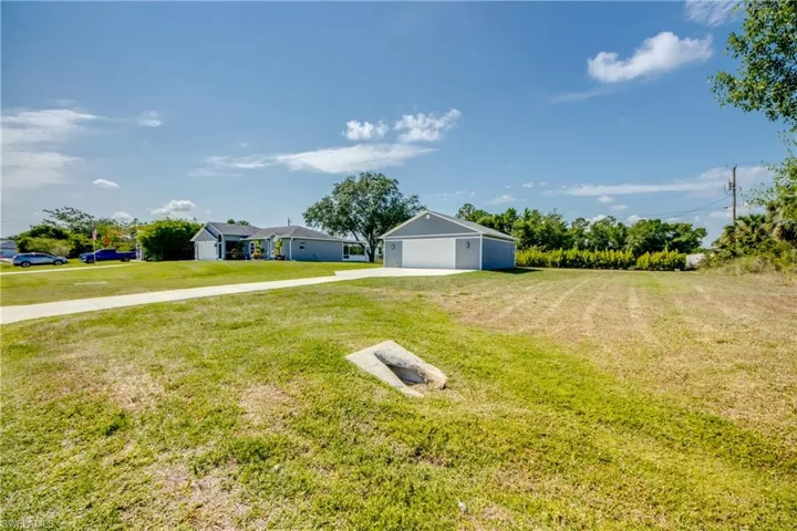 View of grassy yard featuring driveway