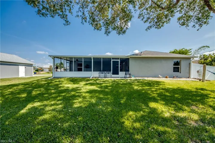 Rear view of property featuring a sunroom and stucco siding
