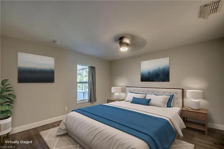 Master bedroom with baseboards and wood finished floors