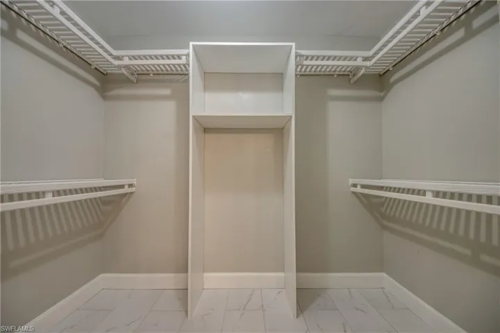 Walk in closet featuring marble finish flooring