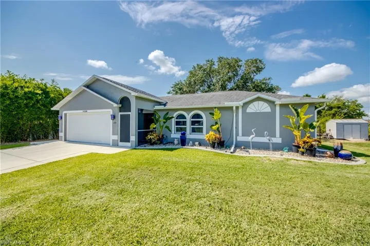 Ranch-style home featuring concrete driveway, an attached garage, a front yard, and stucco siding