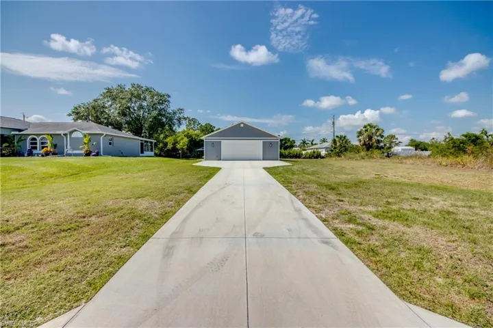 Ranch-style house featuring a front yard, driveway, and a garage