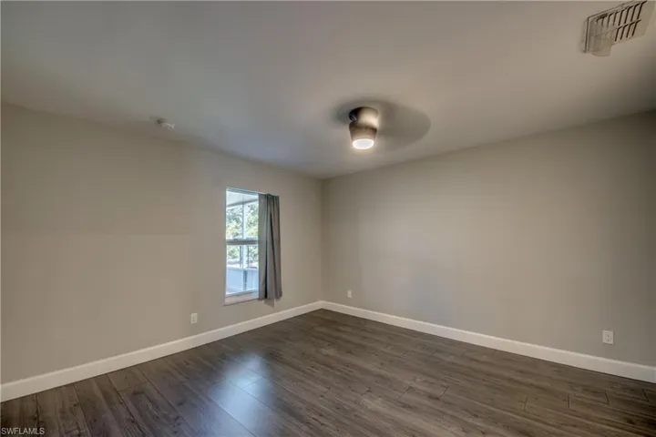 master bedroom featuring dark wood-type flooring, baseboards, and a smoke detector
