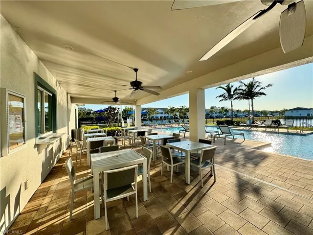 View of patio / terrace featuring a ceiling fan, outdoor dining area, and a community pool