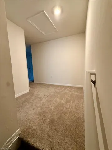 Empty room featuring carpet flooring and baseboards