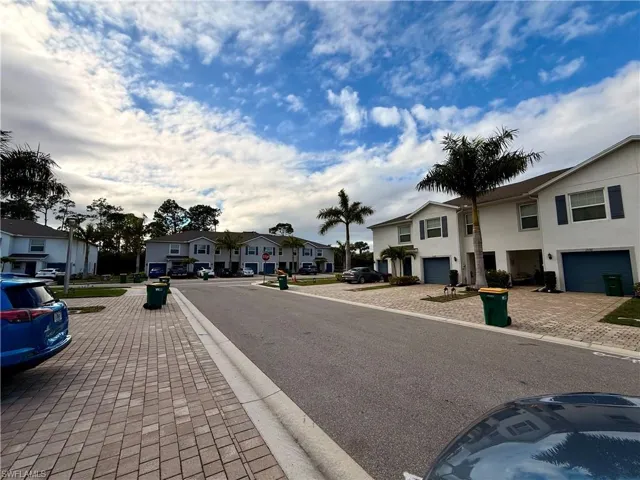 View of asphalt street featuring a residential view, sidewalks, and curbs