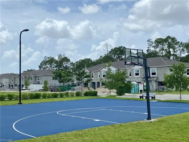 View of sport court featuring community basketball court, a residential view, and a yard