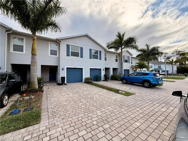 View of front of home featuring decorative driveway, stucco siding, and a residential view