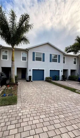 View of front of property with decorative driveway and stucco siding