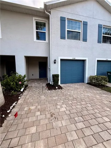 View of front of home featuring stucco siding and decorative driveway