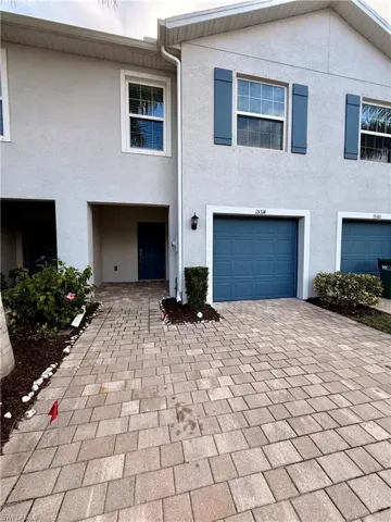 View of front of home with stucco siding and decorative driveway